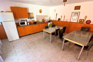 a kitchen with a table and chairs and a refrigerator at Pensiunea Ramona in Brezoi