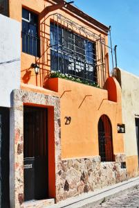 um edifício laranja com uma porta e uma janela em Casa Geranios Tequisquiapan em Tequisquiapan