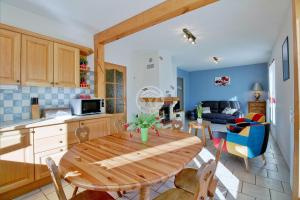 cocina y sala de estar con mesa de madera y sillas en Gîte des Moulins - Val d'Azun Pyrénées, en Arcizans-Dessus