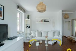 a living room with a white couch and a table at Apartamenty.in Jurata Ratibora 66 in Jurata