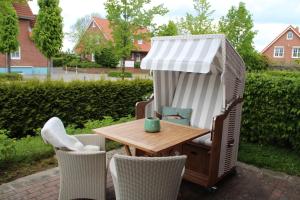 a table and chairs in a backyard with a shed at Strandbude16 in Timmendorfer Strand