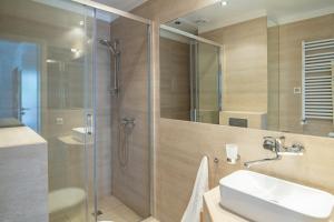 a bathroom with a shower and a sink and a glass shower stall at Apartamenty In Jurata Ratibora 66 in Jurata +10 photos