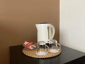 a coffee pot and two glasses on a table at Maksim Hotel in Yekaterinburg