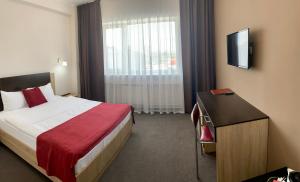 Un pat sau paturi într-o cameră la Maksim Hotel