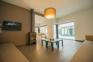 a living room with a table and a fireplace at Villa Fluisterbos met gratis parking in Ostend