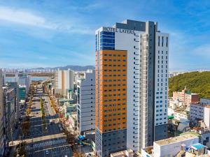 釜山的住宿－Layers Hotel Busan Hadan，上面有活塞租赁标志的高楼