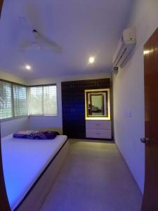 a room with a bed and a mirror in it at Serenity 1BHK apartment, Alibag in Alibaug