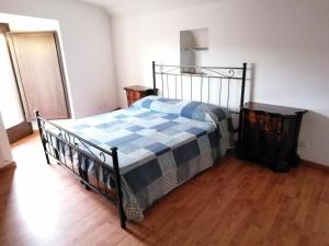 a bedroom with a bed with a blue and white blanket at CASA a TORRE - GANGI CENTRO in Gangi