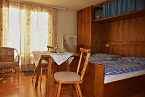 1 dormitorio con 1 cama, mesa y sillas en Pension Alpentraum, en Zell am See