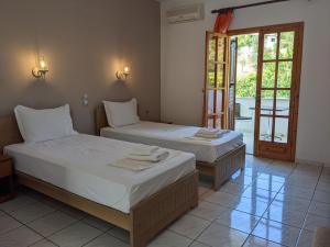 1 dormitorio con 2 camas y puerta a un patio en Dream House, en Agia Paraskevi