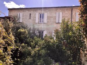 ein altes Backsteingebäude mit Bäumen davor in der Unterkunft Hôtel Saint Louis in Aigues-Mortes