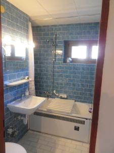 a bathroom with a sink and a blue tile wall at Ferienwohnung am Cambomare in Kempten