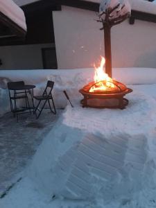 miejsce na ognisko w śniegu ze stołem i krzesłami w obiekcie Wittner's w mieście Söll