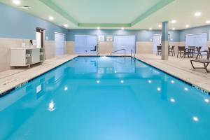 uma grande piscina com água azul num edifício em Holiday Inn Express & Suites - Milan - Sandusky Area, an IHG Hotel em Milan