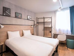 um quarto de hotel com uma cama grande e uma secretária em ibis Avignon Sud em Avignon