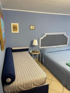 a bedroom with two beds and a table with a lamp at B&B Casa Avallone in Naples