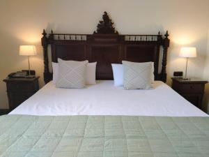 1 dormitorio con 1 cama grande con sábanas y almohadas blancas en Hotel Rural Victoria en La Orotava