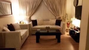 Una sala de estar con un sofá y una mesa de café. en Eden appartment in lahore, en Lahore 9 fotos más