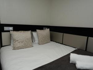 a bed with white sheets and pillows on it at Great St Helen Hotel in London