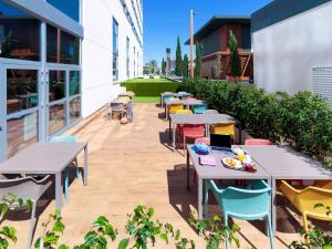 a patio with tables and chairs on the side of a building at ibis budget Huerta De Murcia in Murcia