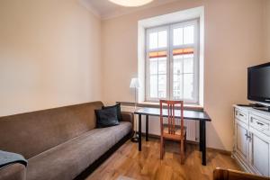 a living room with a couch and a table at Apartamenty Lea 17 WAWELOFTS in Krakow