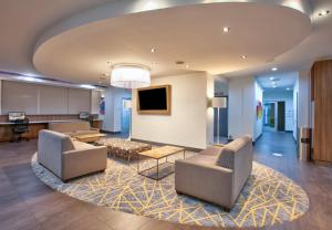 a living room with couches and a tv and a rug at Holiday Inn Dallas - Fort Worth Airport South by IHG in Euless