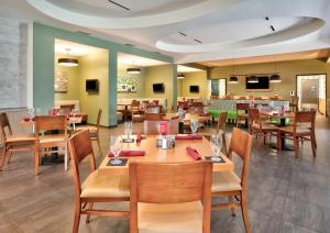 a dining room with wooden tables and chairs at Holiday Inn Dallas - Fort Worth Airport South by IHG in Euless