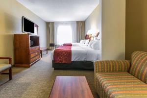 a hotel room with a bed and a couch at Comfort Suites in Owensboro