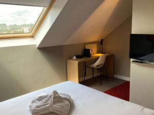 a room with a bed and a desk and a window at Ibis Wavre Brussels East in Wavre