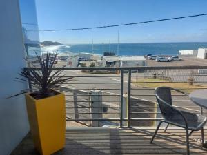 einen Balkon mit einem Tisch und Stühlen sowie Blick auf einen Parkplatz in der Unterkunft The Hampton Exclusive Guesthouse in East London