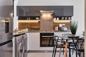 a kitchen with stainless steel appliances and a table with chairs at CAG The View Morningside in Johannesburg