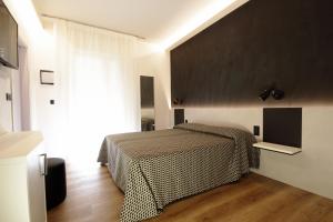 a bedroom with a bed and a large window at Hotel Toledo in Lido di Jesolo