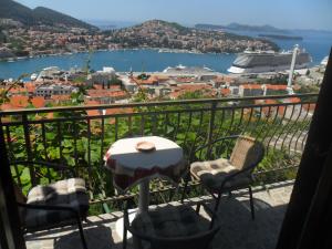 einen Tisch und Stühle auf einem Balkon mit Aussicht in der Unterkunft Pansion Panorama Dubrovnik in Dubrovnik