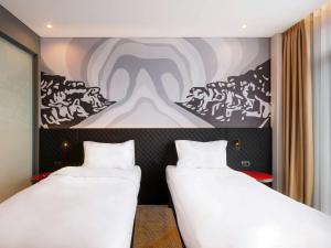 duas camas num quarto com um quadro na parede em ibis Styles Istanbul Merter em Istambul