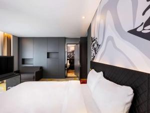 ibis Styles Istanbul Merter في إسطنبول: غرفة نوم بسرير كبير وغرفة معيشة