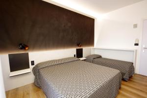 1 dormitorio con 2 camas y una pizarra en la pared en Hotel Toledo, en Lido di Jesolo