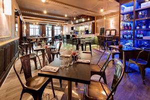 a dining room with tables and chairs in a restaurant at Hotel Saint Louis - Au Coeur des Remparts in Aigues-Mortes