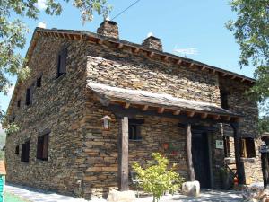 an old stone building with a roof at La Era de la Tía Donata in Campillo de Ranas