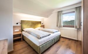 a bedroom with a bed and a window at Apartments Sayonara in Castelrotto