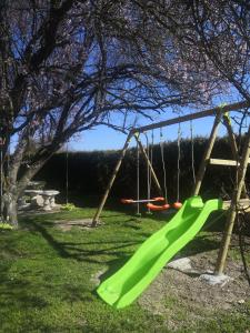 een speeltuin met een groene glijbaan in een tuin bij La longère Champenoise in Prugny