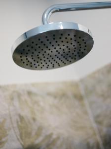 a shower light hanging from a white wall at Weingut Straka in Rechnitz