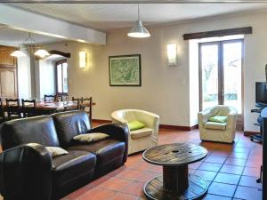 Una sala de estar con un sofá y sillas y una mesa. en Élégante maison de maître XVIIIe, jardin clos 500m², nature, proche Puy-en-Velay, 11 pers., cosy & confort - FR-1-582-315, en Arsac-en-Velay