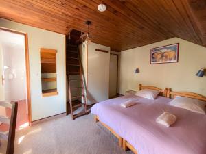 a bedroom with two beds and a wooden ceiling at Doume's Lodge in Les Deux Alpes