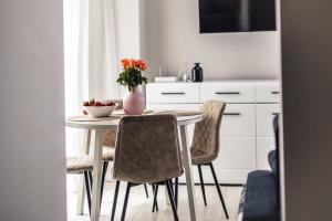 tavolo da pranzo con sedie e vaso con fiori di NEW modern studio apartment in the Old Town Riga a Riga