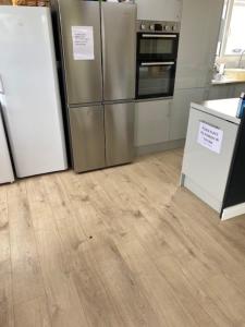 a kitchen with stainless steel appliances and wooden floors at Bucks accommodation in Aylesbury