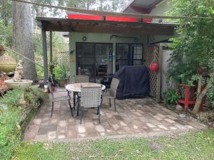 a patio with a table and chairs in a backyard at Werekataba in Mount Hutton