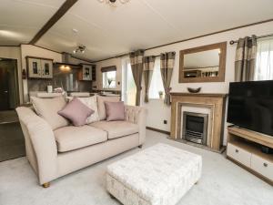 uma sala de estar com um sofá e uma televisão em Ashton Lodge - Sherwood 4 em Carnforth