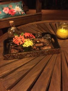 a tray with flowers on top of a wooden table at Rêve Et Alizé in Bouillante