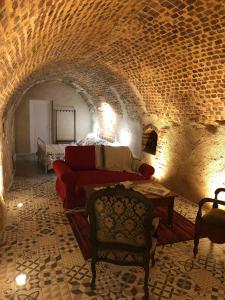 uma sala de estar com um sofá e uma cama num túnel em Gîte semi-troglodytique du Vieux Chai de Trôo em Trôo