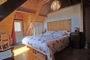 TrôoにあるGîte semi-troglodytique du Vieux Chai de Trôoの木造家屋内のベッドルーム(ベッド付)